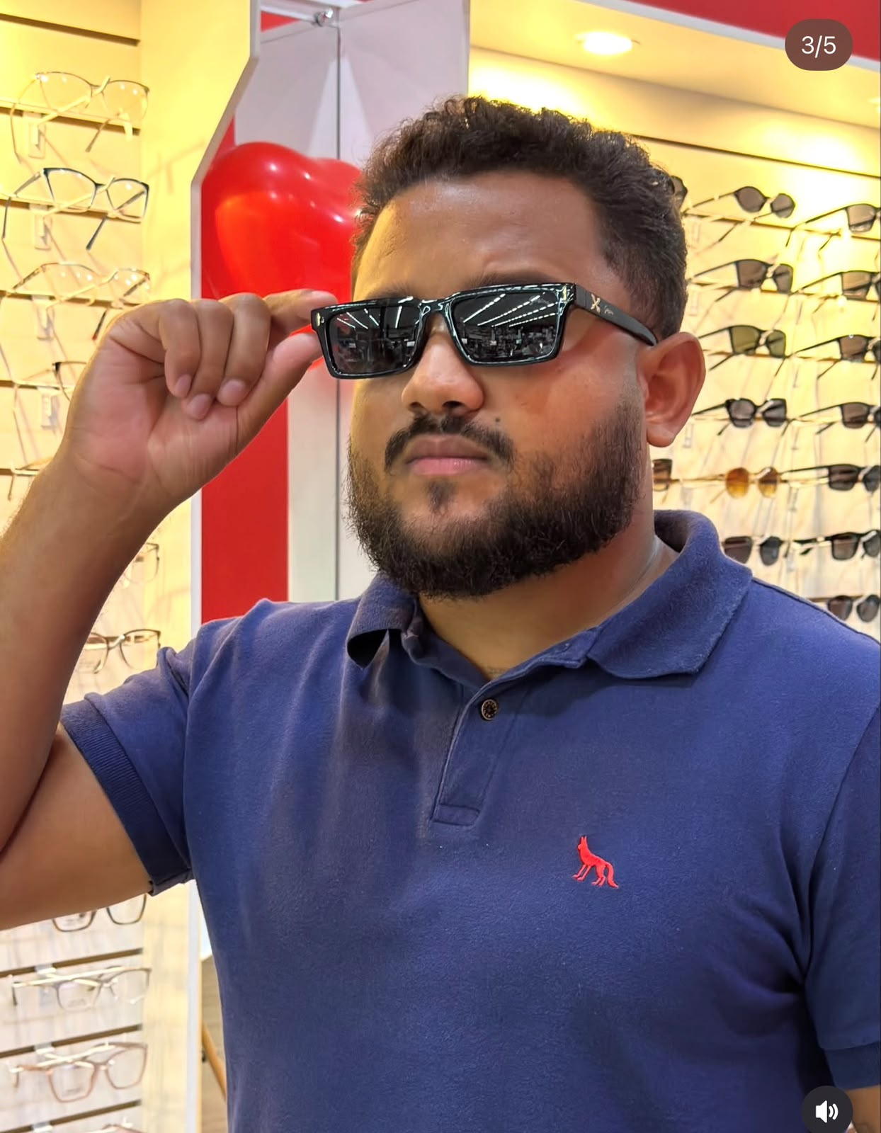 Cliente experimentando óculos solares pretos na Ótica Preço Bom